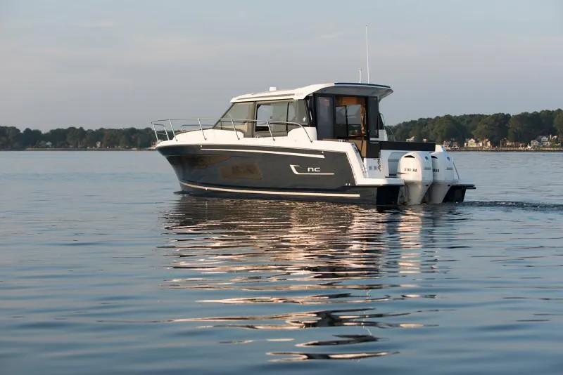 Slide: The Image of 2025 Jeanneau NC1095 Coupe boat cruising on calm water, side view. - 7