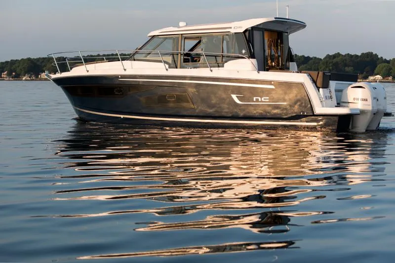 Slide: The Image of 2025 Jeanneau NC1095 Coupe boat on calm water, side view. - 8