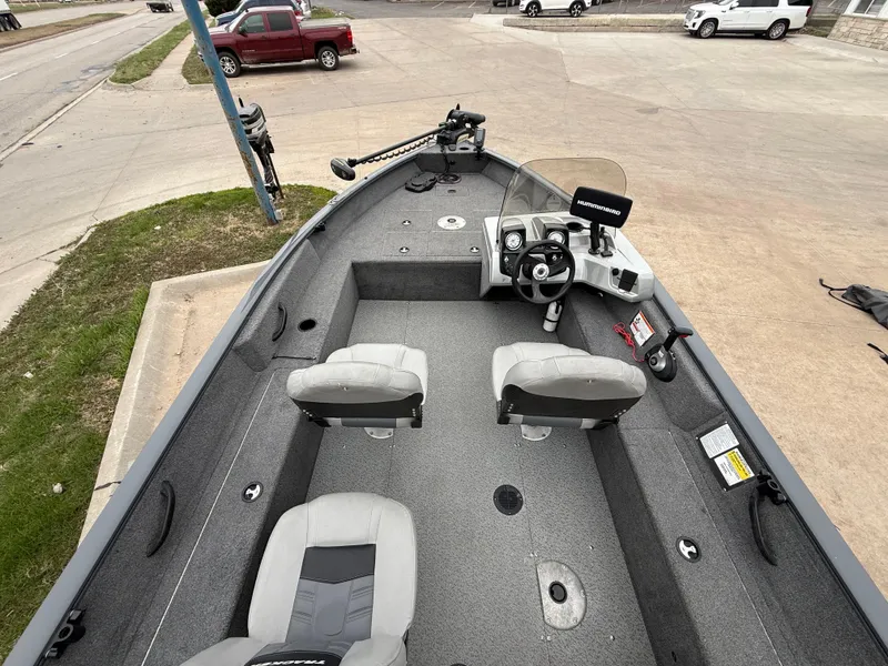 Slide: The Image of 2017 Tracker Pro Guide V-16 SC boat with dual seats and steering console, parked on pavement. - 9