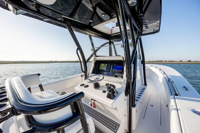 Slide: The Image of 2014 SeaHunter 32 Tournament boat cockpit with navigation equipment on calm water. - 15