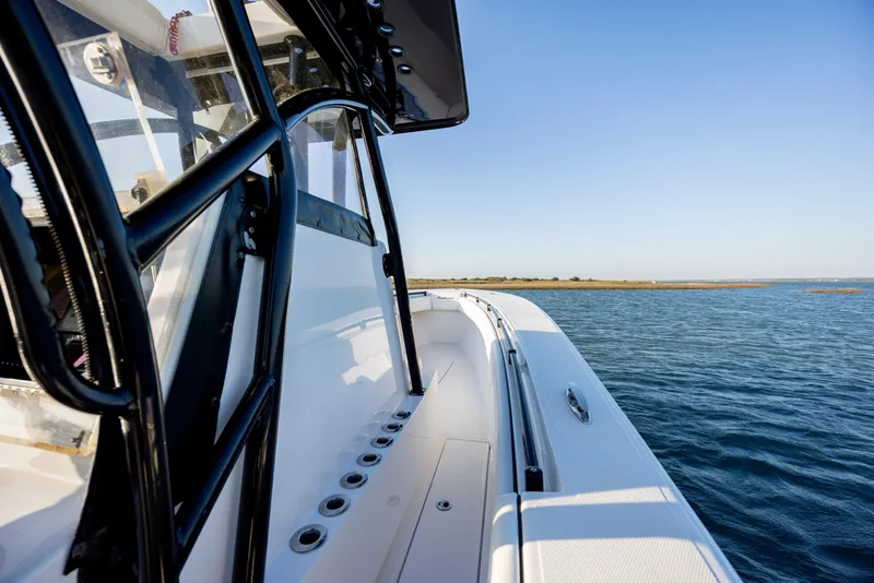 Slide: The Image of 2014 SeaHunter 32 Tournament boat on calm waters, showcasing sleek design and spacious deck. - 19