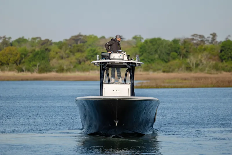 Slide: The Image of 2014 SeaHunter 32 Tournament boat navigating calm waters with lush greenery in the background. - 2