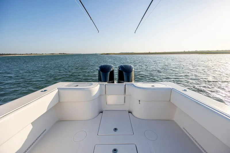 Slide: The Image of 2014 SeaHunter 32 Tournament boat on calm water, showcasing spacious deck and dual engines. - 21