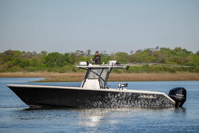 Slide: The Image of 2014 SeaHunter 32 Tournament boat on calm water with lush green background. - 4