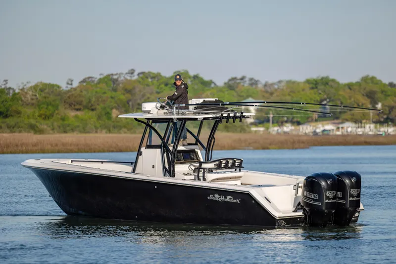 Slide: The Image of 2014 SeaHunter 32 Tournament boat with triple Yamaha engines on a calm waterway. - 5