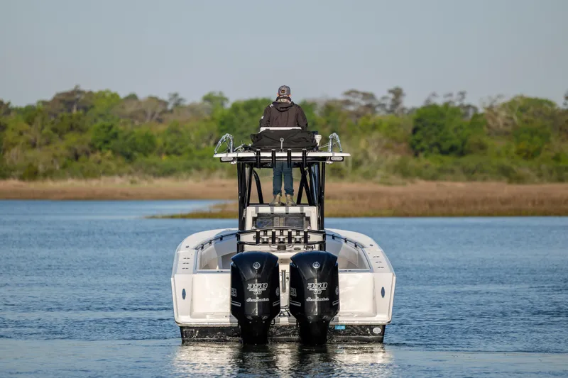 Slide: The Image of 2014 SeaHunter 32 Tournament boat with dual engines on a calm waterway. - 6