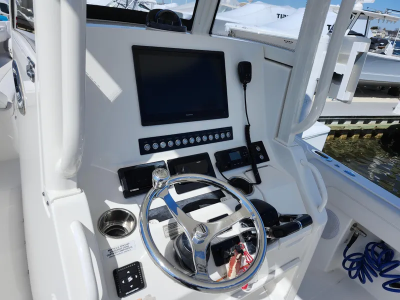 Slide: The Image of 2020 Regulator 25 boat dashboard with steering wheel, controls, and display screen. - 11
