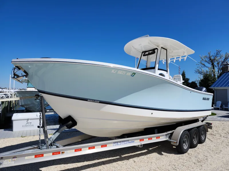 Slide: The Image of 2020 Regulator 25 boat on a trailer, displayed outdoors under a clear blue sky. - 2