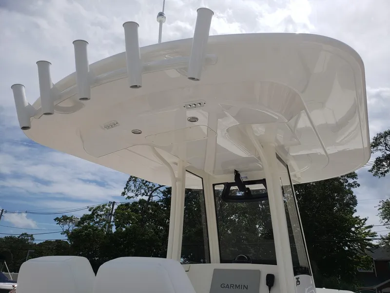 Slide: The Image of 2020 Regulator 25 boat with T-top and rod holders under a cloudy sky. - 21