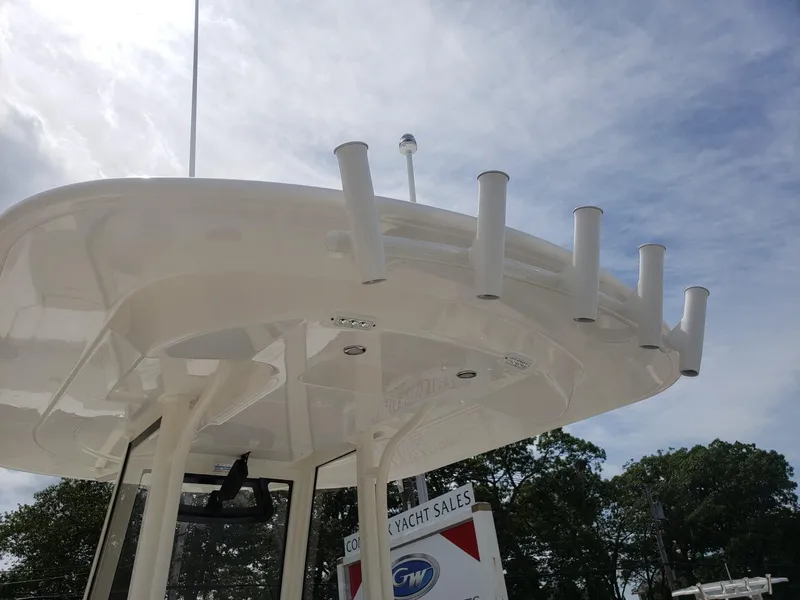 Slide: The Image of 2020 Regulator 25 boat with rod holders and T-top under a cloudy sky. - 22