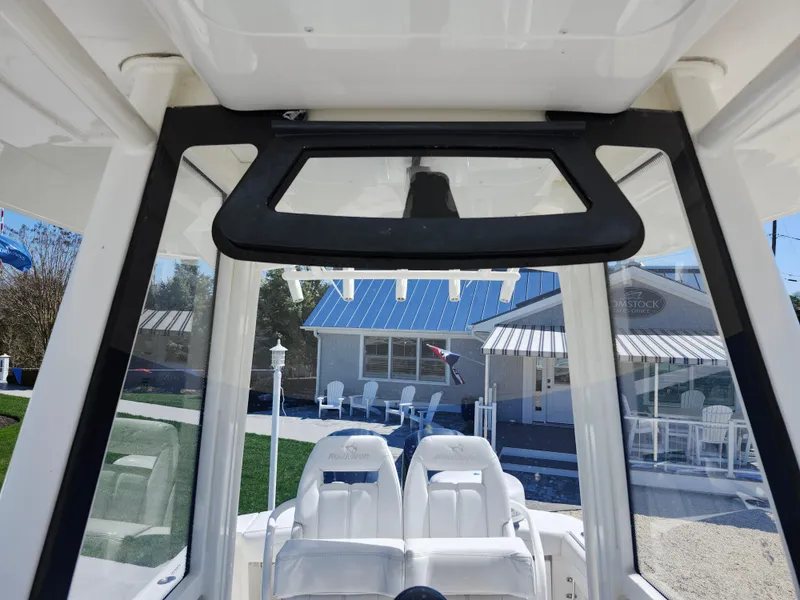 Slide: The Image of 2020 Regulator 25 boat interior with dual white seats and clear windows. - 23