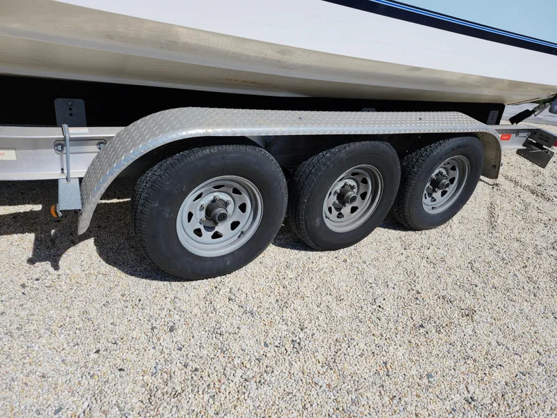 Slide: The Image of Triple-axle trailer for 2020 Regulator 25 boat on gravel surface. - 32