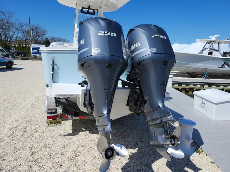 Slide: The Image of 2020 Regulator 25 boat with twin Yamaha 250 outboard engines, parked on gravel. - 5