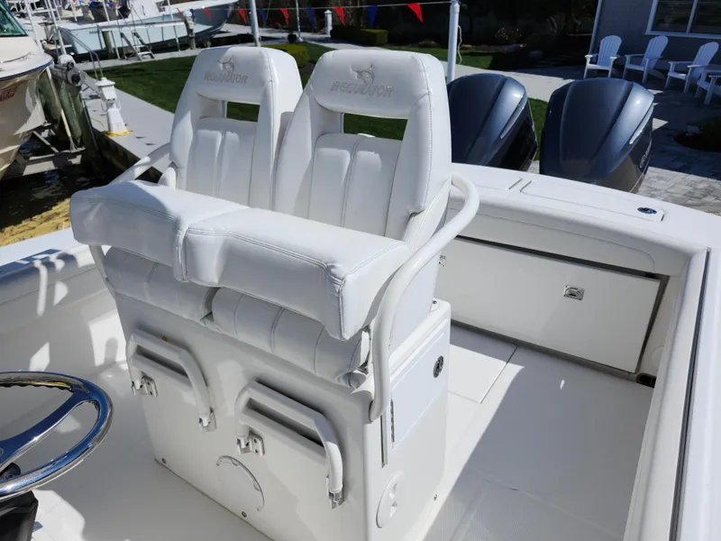 Slide: The Image of 2020 Regulator 25 boat with dual white captain's chairs and sleek design. - 6