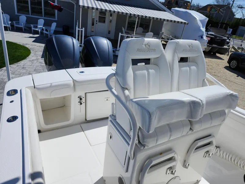Slide: The Image of 2020 Regulator 25 boat with dual engines and white seating in a marina setting. - 7