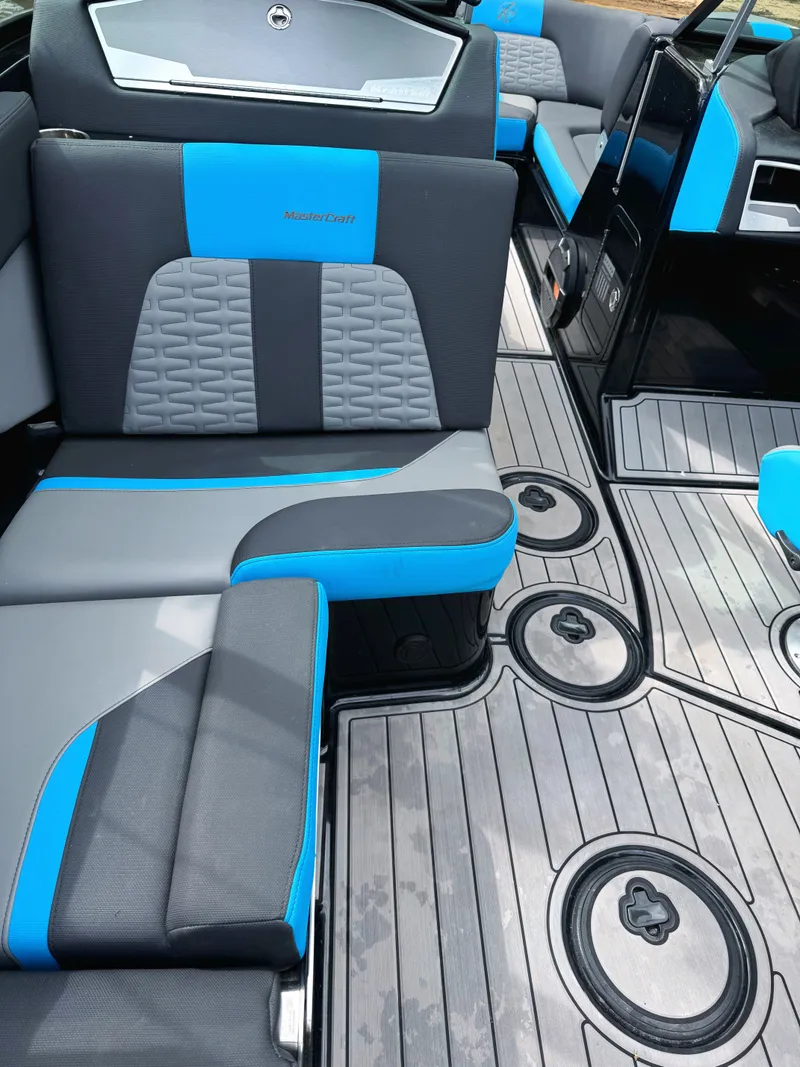 Slide: The Image of 2019 MasterCraft X24 interior with blue and gray seating, modern design, and sleek flooring. - 6