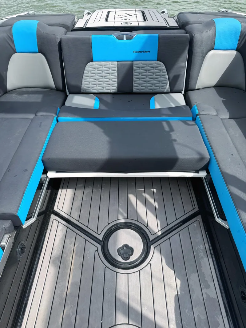 Slide: The Image of 2019 MasterCraft X24 boat interior with blue and gray seating, featuring a sleek design. - 7