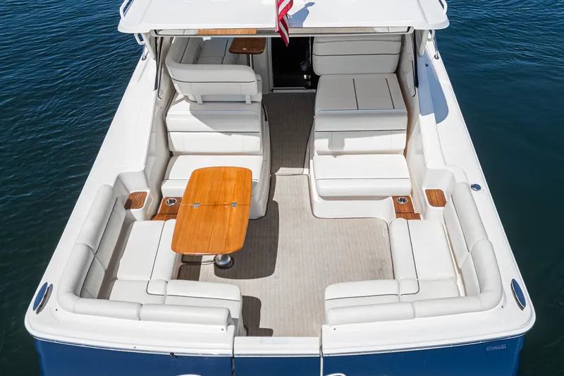 Slide: The Image of 2018 Tiara Yachts 3100 Coronet with spacious seating and wooden table on deck. - 18