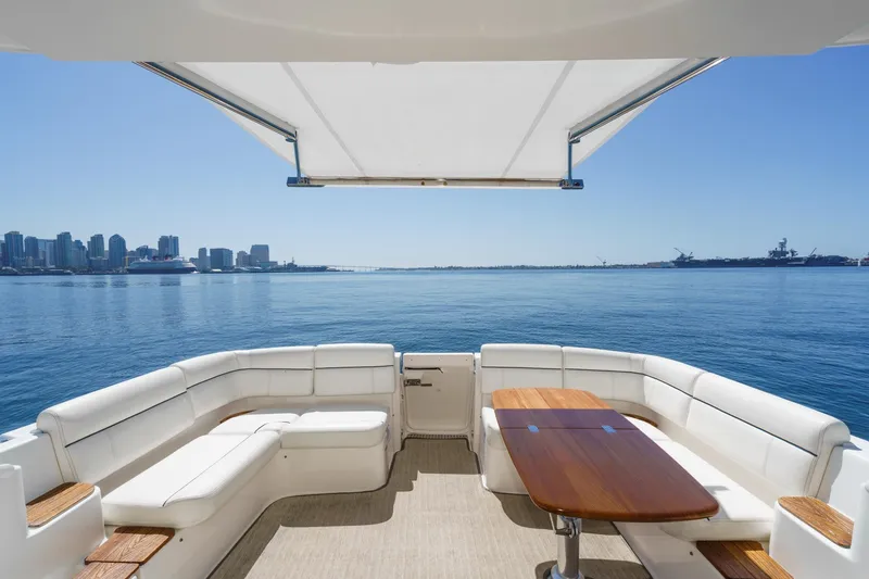 Slide: The Image of 2018 Tiara Yachts 3100 Coronet with spacious seating, overlooking a serene waterfront cityscape. - 21