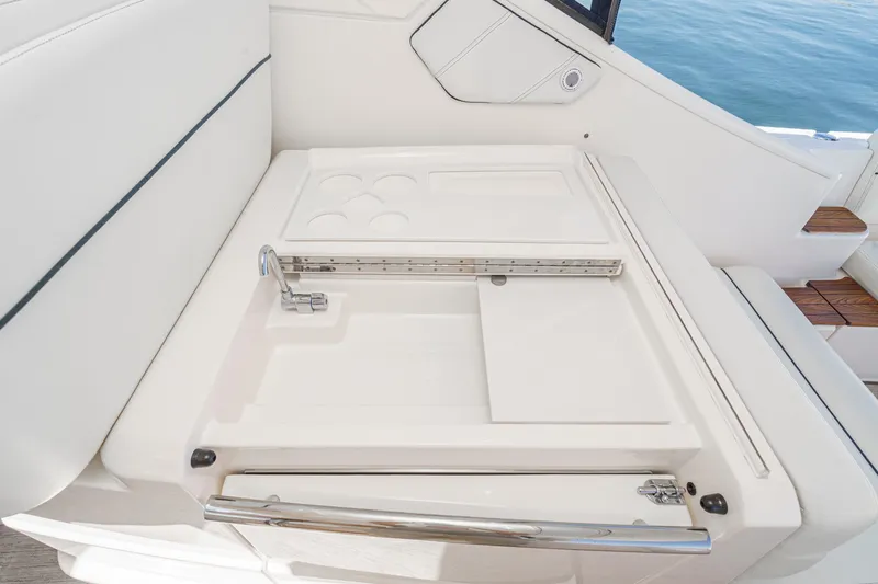 Slide: The Image of 2018 Tiara Yachts 3100 Coronet interior detail with white seating and built-in storage. - 30