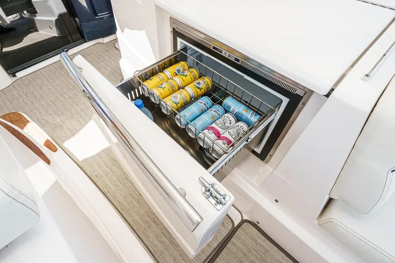 Slide: The Image of Open drawer fridge on 2018 Tiara Yachts 3100 Coronet, stocked with assorted beverage cans. - 32