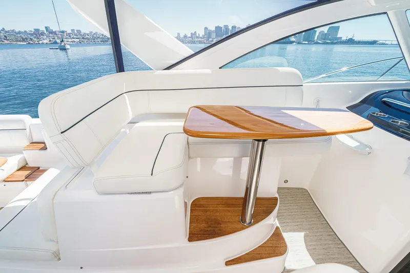 Slide: The Image of 2018 Tiara Yachts 3100 Coronet interior with white seating and wooden table, ocean view. - 33