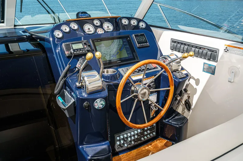 Slide: The Image of 2018 Tiara Yachts 3100 Coronet helm with navigation controls and wooden steering wheel. - 36