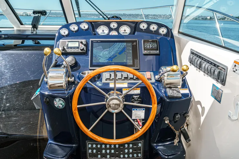 Slide: The Image of 2018 Tiara Yachts 3100 Coronet helm with navigation controls and wooden steering wheel. - 37