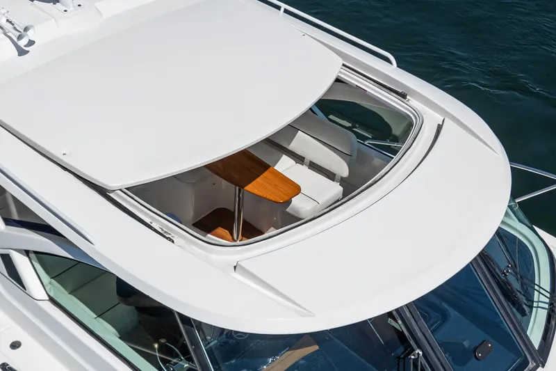 Slide: The Image of 2018 Tiara Yachts 3100 Coronet with open sunroof, showcasing interior seating and table. - 39