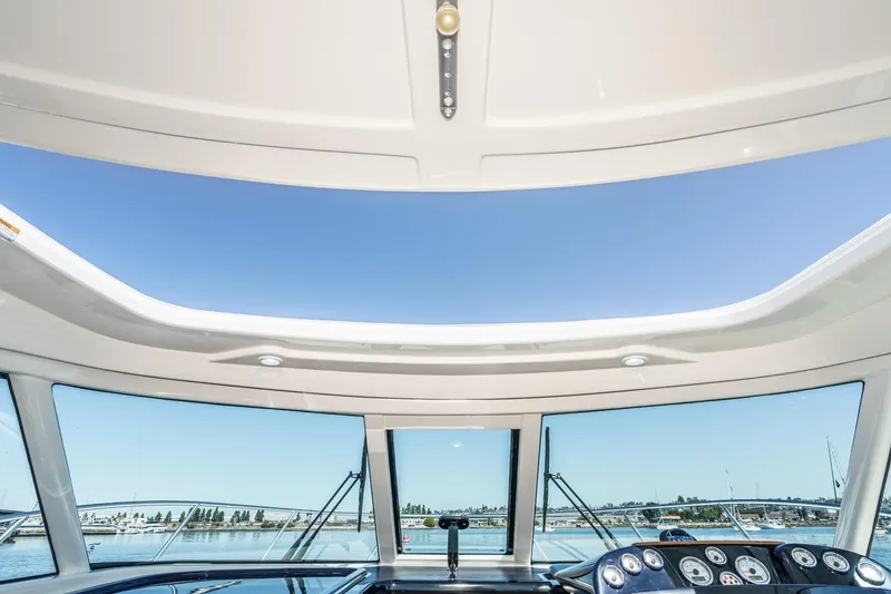 Slide: The Image of 2018 Tiara Yachts 3100 Coronet helm view with open sky and water backdrop. - 47