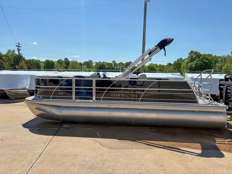 The Image of 2025 Trifecta 22 UL LE T 2.75 pontoon boat on display outdoors. - 1
