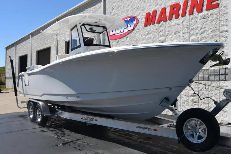 Slide: The Image of 2025 Sea Hunt Gamefish 28 boat on trailer outside marine dealership. - 2
