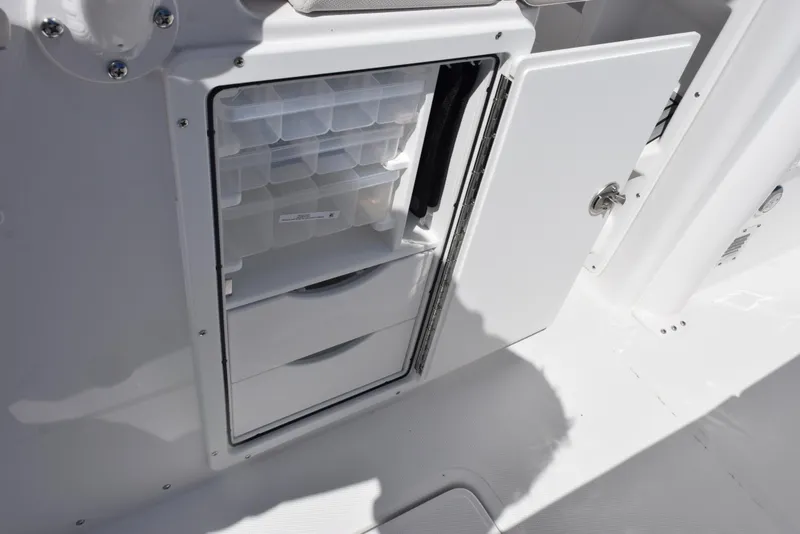 Slide: The Image of 2025 Sea Hunt Gamefish 28 storage compartment with organized tackle boxes and drawers. - 21