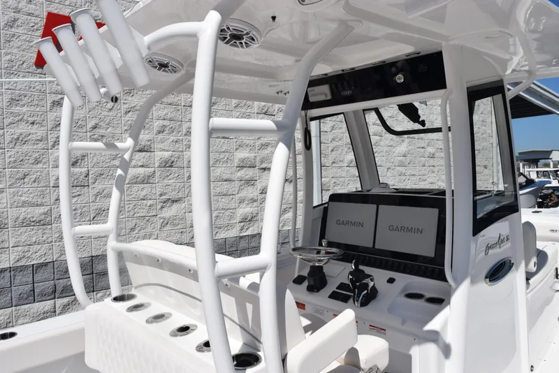 Slide: The Image of 2025 Sea Hunt Gamefish 28 boat cockpit with Garmin displays and rod holders. - 9