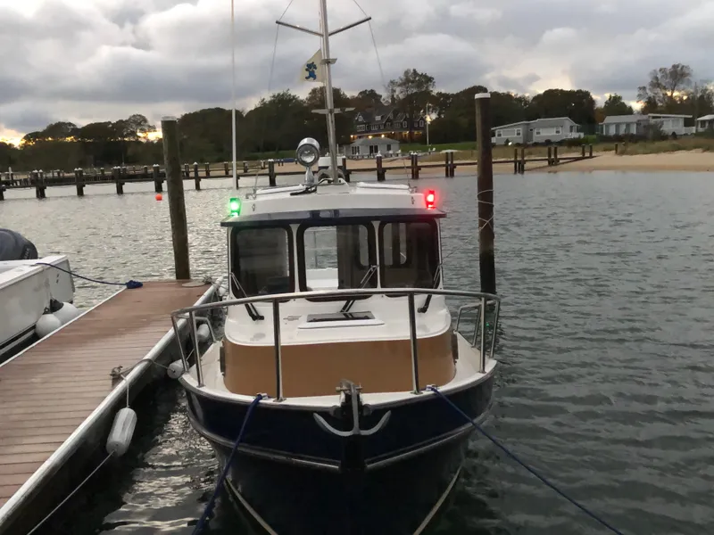 Slide: The Image of 2013 Ranger Tugs R-21 EC docked at a marina, overcast sky in background. - 4