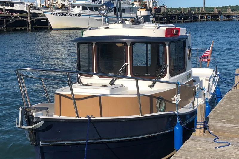Slide: The Image of 2013 Ranger Tugs R-21 EC docked at a marina with American flag. - 7