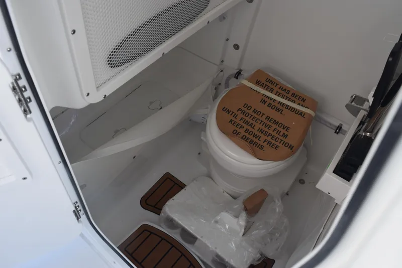 Slide: The Image of 2025 Sea Hunt Ultra 265 SE boat interior with toilet and storage area. - 16