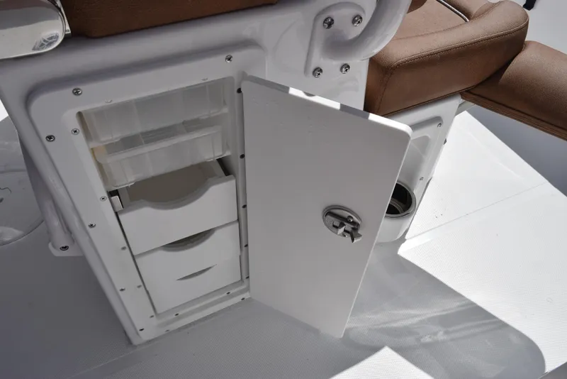 Slide: The Image of Open storage compartment on 2025 Sea Hunt Ultra 265 SE boat with brown seating. - 18