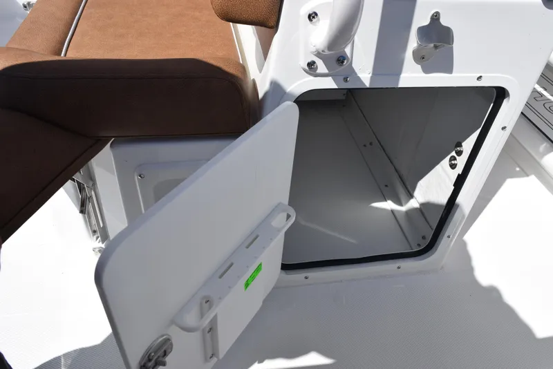 Slide: The Image of Open storage compartment on 2025 Sea Hunt Ultra 265 SE boat with brown seating. - 20