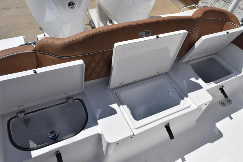 Slide: The Image of 2025 Sea Hunt Ultra 265 SE boat with open storage compartments and brown seating. - 22