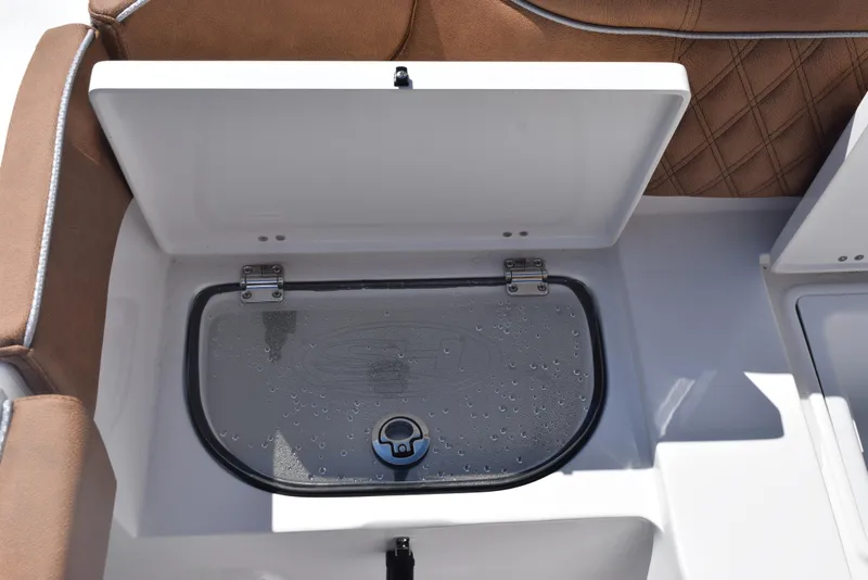 Slide: The Image of Open storage compartment on 2025 Sea Hunt Ultra 265 SE boat with cushioned seating. - 23