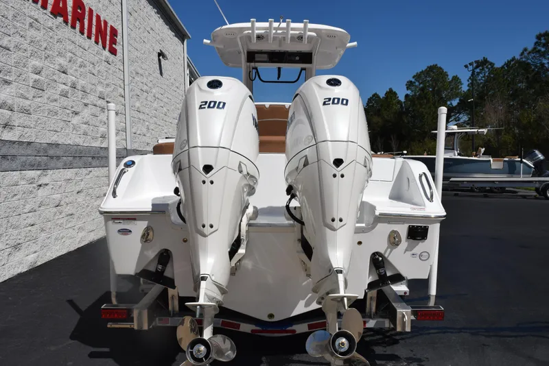 Slide: The Image of 2025 Sea Hunt Ultra 265 SE boat with dual 200 horsepower engines, docked outdoors. - 4