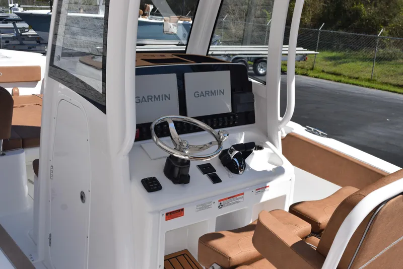 Slide: The Image of 2025 Sea Hunt Ultra 265 SE boat dashboard with dual Garmin displays and steering wheel. - 8