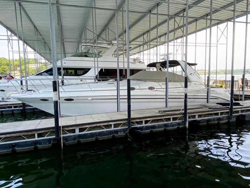 The Image of 1997 Sea Ray 400 Sundancer yacht docked under a covered marina. - 1