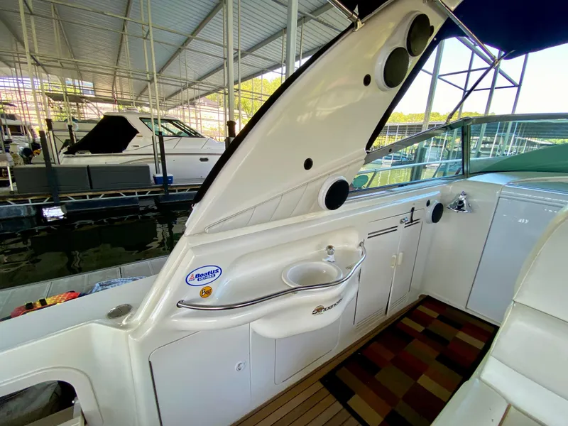 Slide: The Image of 1997 Sea Ray 400 Sundancer yacht interior with sink and seating area in marina. - 10
