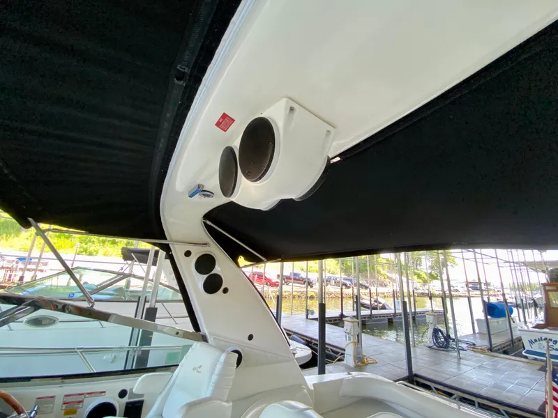 Slide: The Image of 1997 Sea Ray 400 Sundancer boat interior with speakers and canopy at a marina. - 11