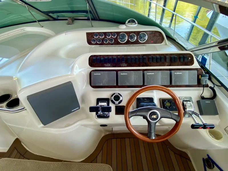 Slide: The Image of Cockpit of 1997 Sea Ray 400 Sundancer with wooden steering wheel and control panel. - 12