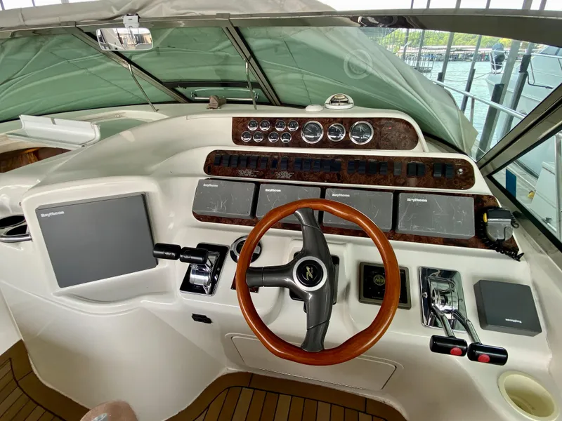 Slide: The Image of Cockpit of 1997 Sea Ray 400 Sundancer with wooden steering wheel and modern controls. - 15