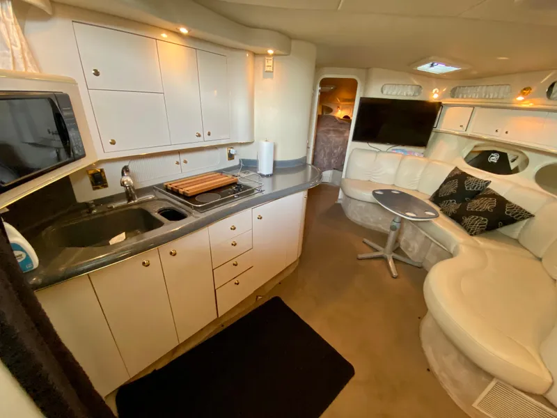 Slide: The Image of Interior of 1997 Sea Ray 400 Sundancer yacht with kitchen and seating area. - 19