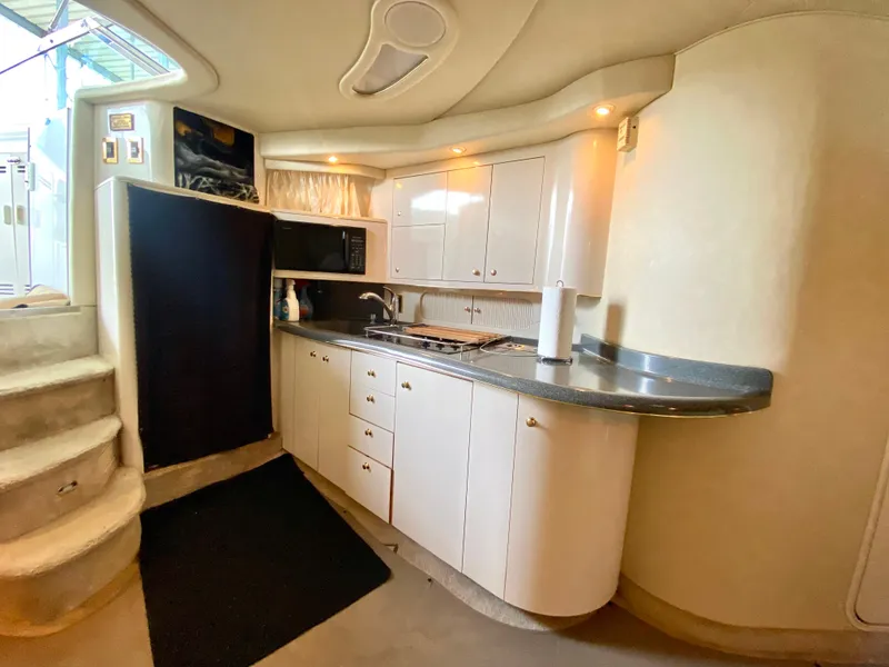 Slide: The Image of 1997 Sea Ray 400 Sundancer yacht interior kitchen with white cabinets and modern appliances. - 21